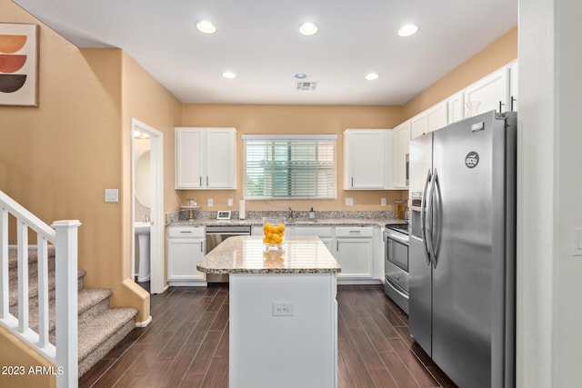 2031 N 77th Ln, Phoenix, AZ 85035 - kitchen with appliances with stainless steel finishes, a kitchen island, white cabinetry, light stone countertops, and recessed lighting