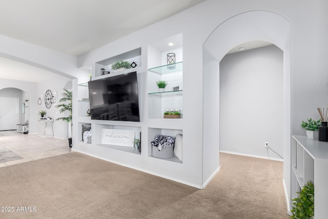 living room with built in features and light colored carpet