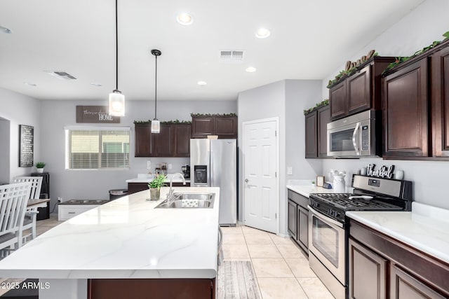 kitchen with sink, dark brown cabinets, a center island with sink, and appliances with stainless steel finishes