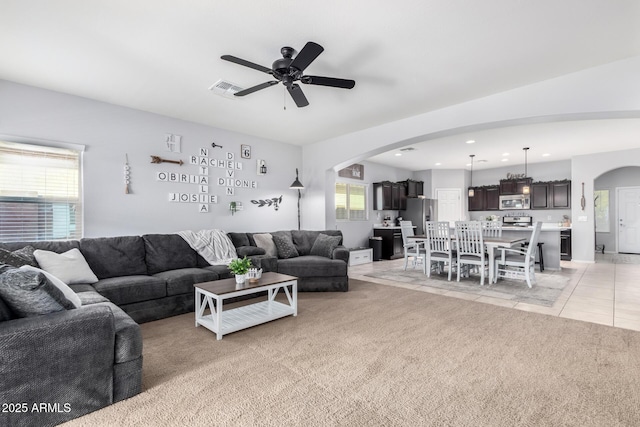 tiled living room with ceiling fan and plenty of natural light