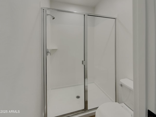 bathroom with toilet and a shower stall