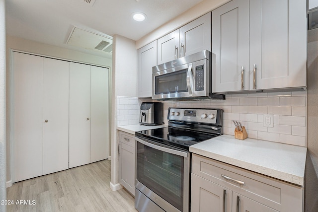 kitchen featuring light hardwood / wood-style flooring, stainless steel appliances, and tasteful backsplash