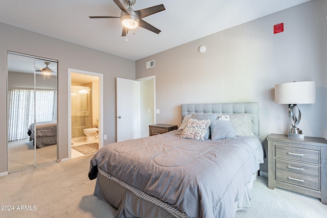 carpeted bedroom featuring connected bathroom, ceiling fan, and a closet