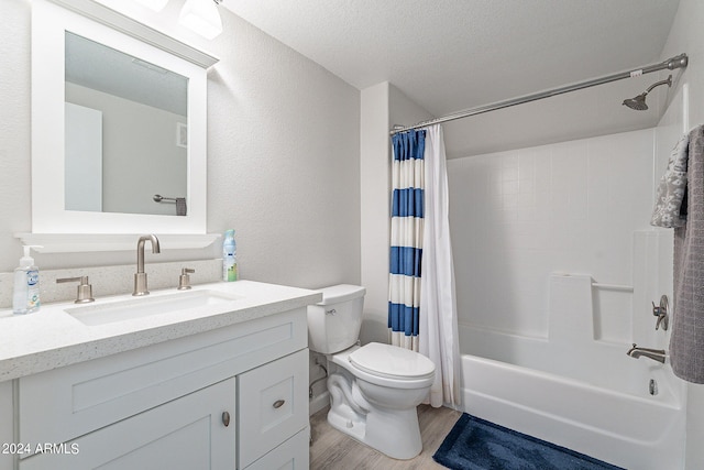 full bathroom with vanity, shower / bath combo, a textured ceiling, hardwood / wood-style flooring, and toilet