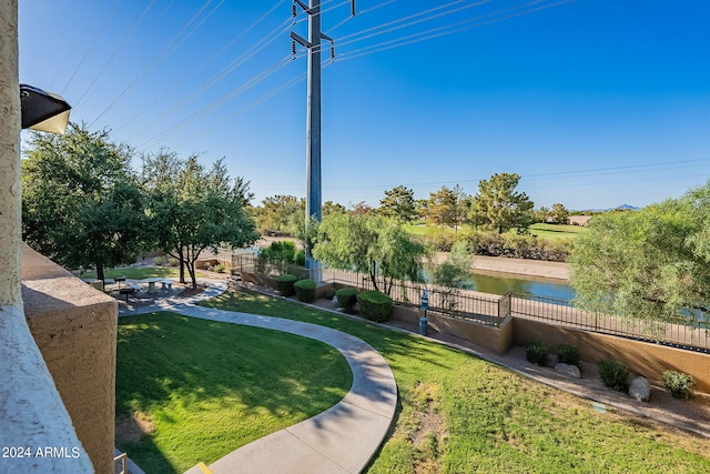 surrounding community with a lawn and a water view