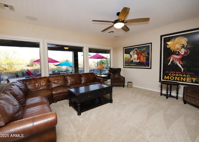 carpeted living room featuring a ceiling fan, visible vents, and baseboards