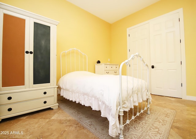 bedroom featuring stone finish flooring and baseboards