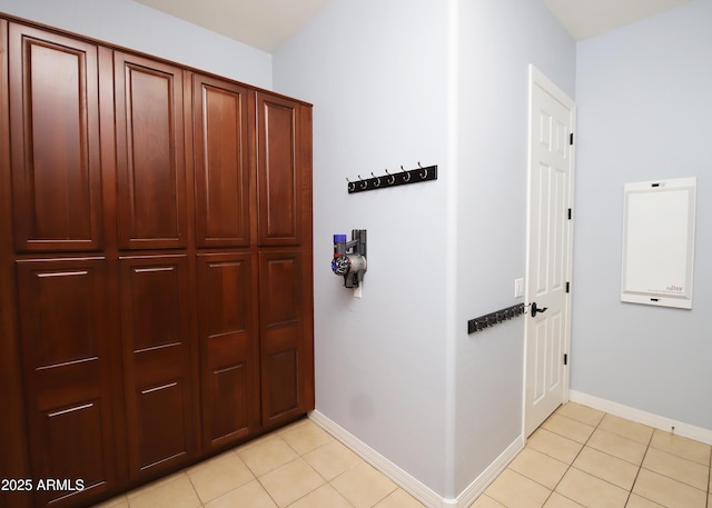 hallway with baseboards and light tile patterned flooring