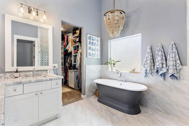 4132 N 42nd St, Phoenix, AZ 85018 - bathroom featuring vanity, a spacious closet, a freestanding tub, a chandelier, and marble look tile flooring