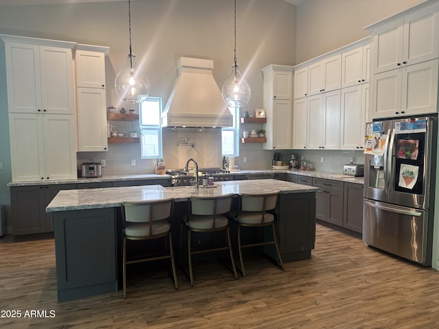 4132 N 42nd St, Phoenix, AZ 85018 - kitchen with stainless steel fridge, custom exhaust hood, open shelves, a kitchen island with sink, and a high ceiling