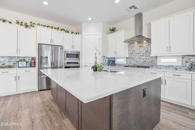 24314 N 21st Pl, Phoenix, AZ 85024 - kitchen with appliances with stainless steel finishes, wall chimney range hood, a sink, an island with sink, and tasteful backsplash