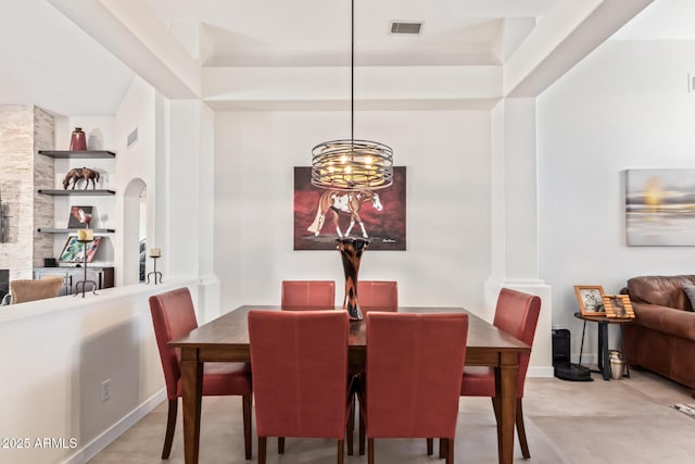 dining room featuring arched walkways, visible vents, and baseboards