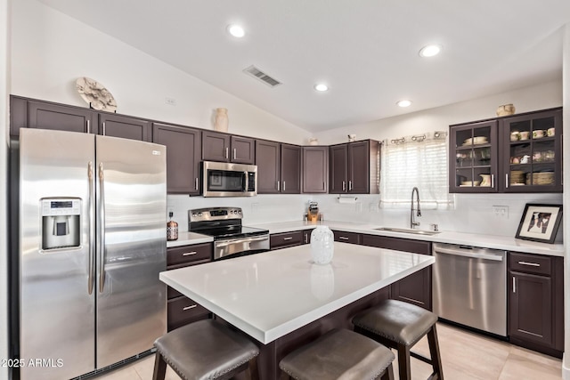 kitchen featuring visible vents, a breakfast bar area, appliances with stainless steel finishes, light countertops, and a sink