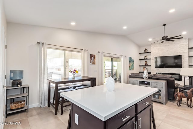 kitchen with vaulted ceiling, light countertops, a kitchen island, and open floor plan