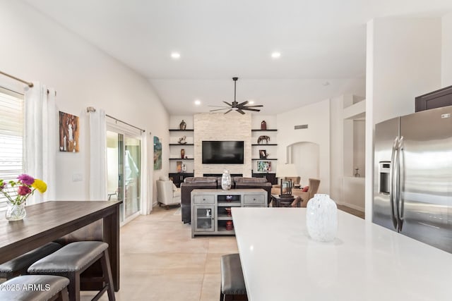 kitchen featuring built in features, stainless steel refrigerator with ice dispenser, light countertops, a ceiling fan, and open floor plan