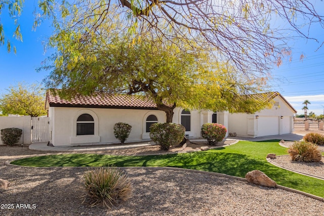 view of front facade featuring a front yard, fence, a tile roof, and stucco siding