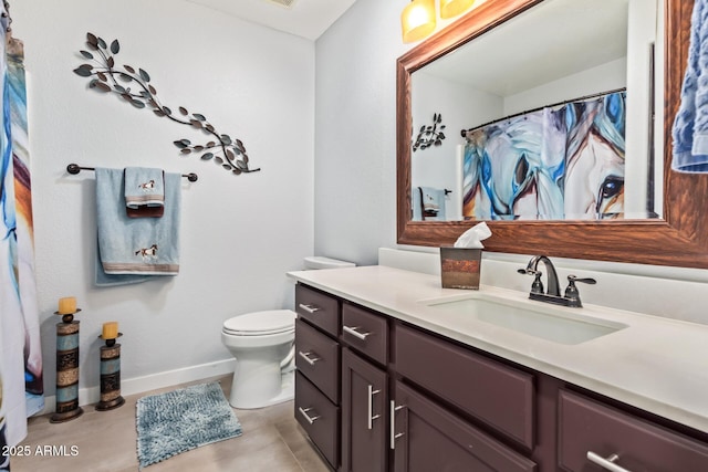 bathroom featuring toilet, baseboards, and vanity