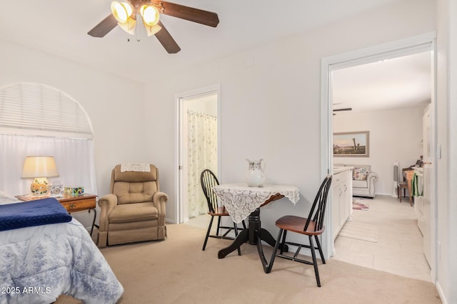 bedroom with light carpet, ceiling fan, and connected bathroom