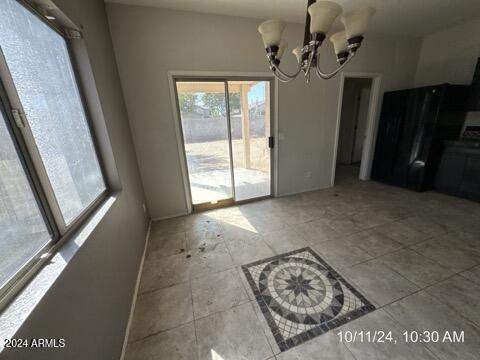 unfurnished dining area featuring a chandelier