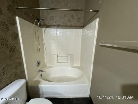 bathroom featuring toilet and washtub / shower combination