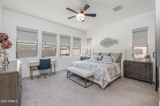 bedroom with light carpet, multiple windows, and ceiling fan