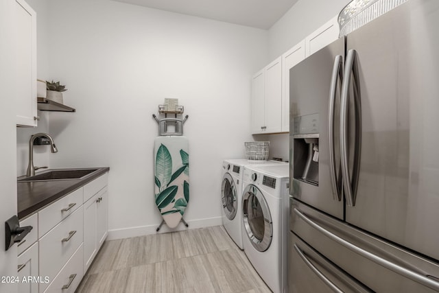 washroom with washer and clothes dryer, sink, light tile flooring, and cabinets