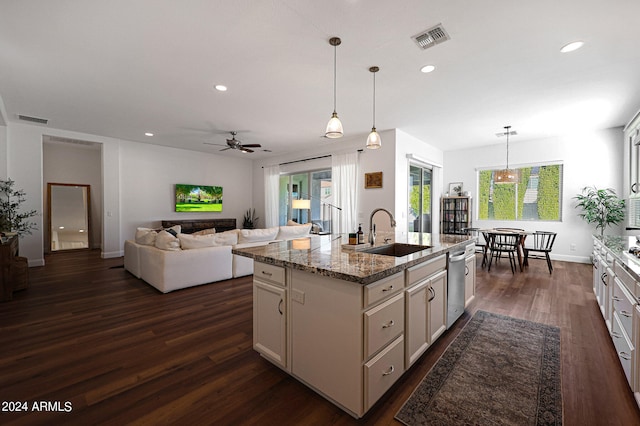 kitchen with decorative light fixtures, dark hardwood / wood-style flooring, a kitchen island with sink, ceiling fan, and sink