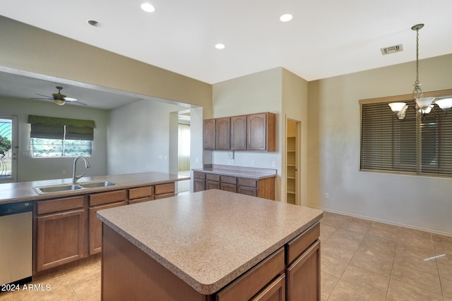 kitchen featuring sink, ceiling fan with notable chandelier, hanging light fixtures, stainless steel dishwasher, and a center island with sink