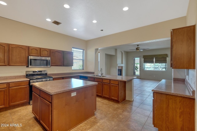 kitchen with a wealth of natural light, a kitchen island, stainless steel appliances, and ceiling fan