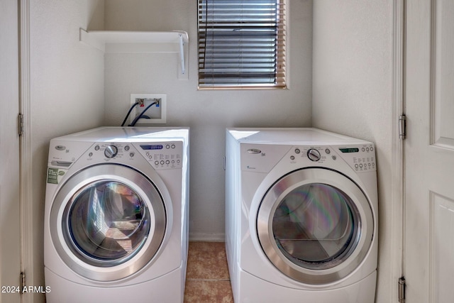 clothes washing area with light tile patterned flooring and independent washer and dryer