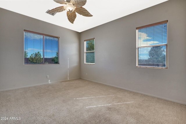 carpeted empty room with a healthy amount of sunlight and ceiling fan