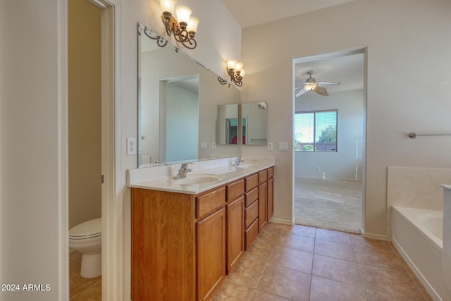 bathroom with ceiling fan, toilet, a washtub, vanity, and tile patterned floors