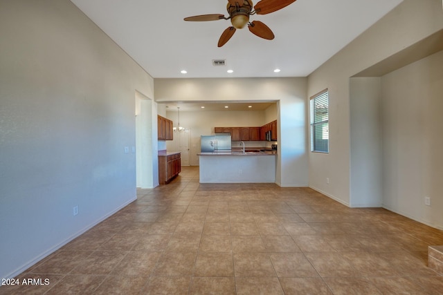 unfurnished living room featuring light tile patterned floors and ceiling fan