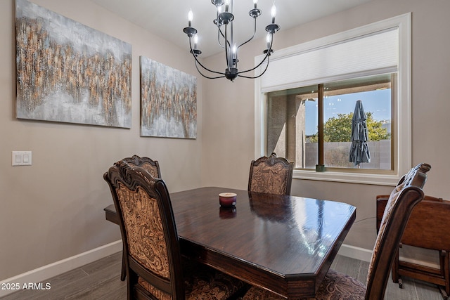 dining area featuring wood-type flooring and a notable chandelier