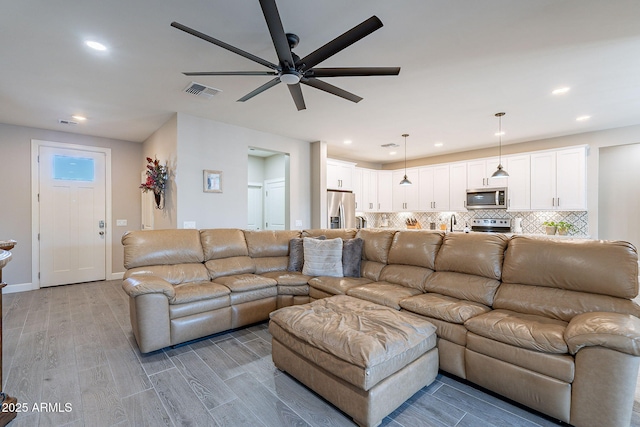 living room with ceiling fan and light hardwood / wood-style flooring