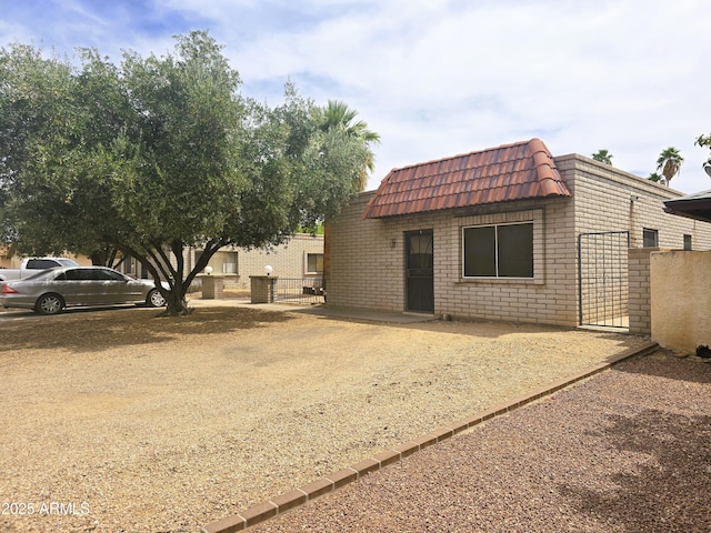 18227 N 40th Pl, Phoenix, AZ 85032 - back of house with mansard roof, fence, a gate, and brick siding