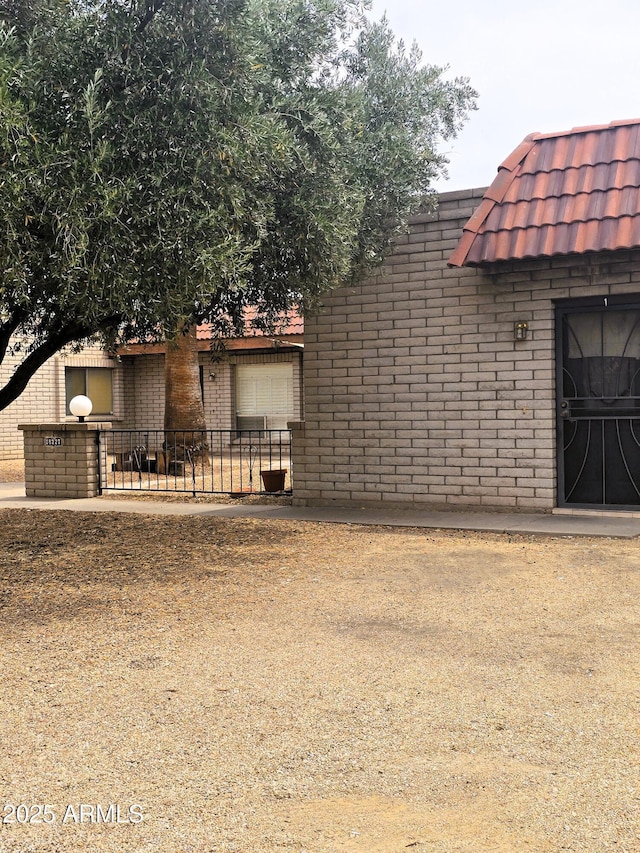 18227 N 40th Pl, Phoenix, AZ 85032 - view of front of house with brick siding, fence, and mansard roof