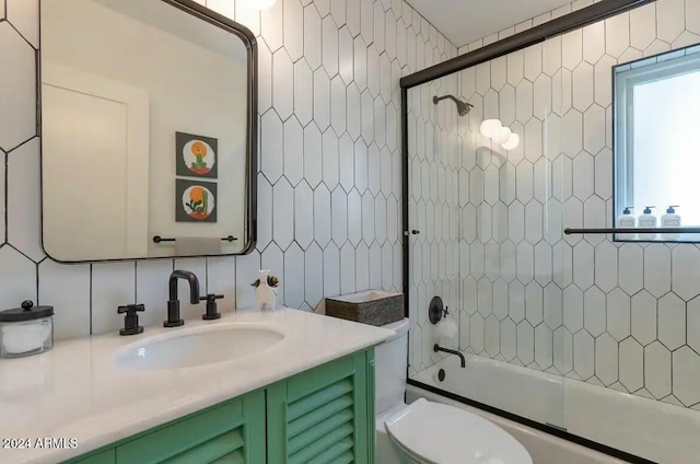 full bathroom with combined bath / shower with glass door, vanity, tasteful backsplash, and tile walls