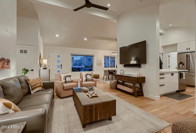 living room with ceiling fan, light wood-type flooring, and high vaulted ceiling