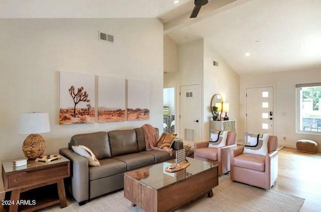 living room featuring beam ceiling, high vaulted ceiling, light hardwood / wood-style flooring, and ceiling fan