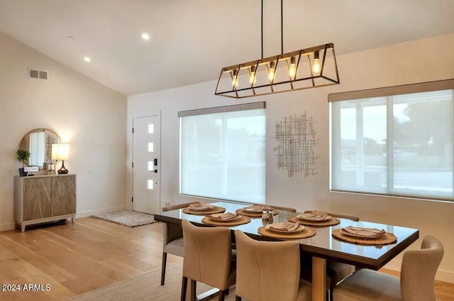 dining area with light hardwood / wood-style floors and lofted ceiling