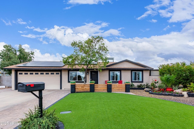 ranch-style house with a garage, a front yard, and solar panels