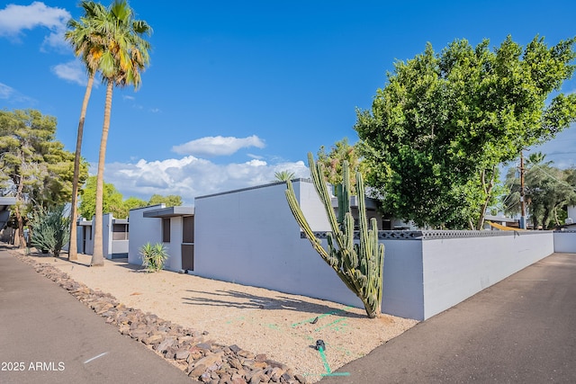 view of property exterior with a fenced front yard and a gate