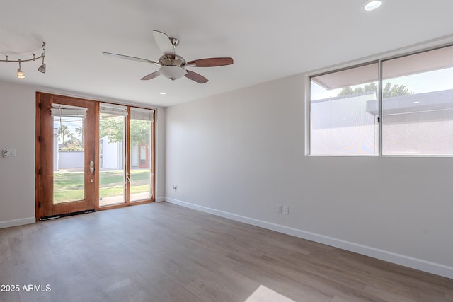 spare room featuring a ceiling fan, baseboards, recessed lighting, and wood finished floors