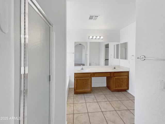 bathroom with vanity, tile patterned floors, and a shower with door