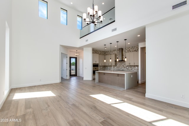 100 W Northern Ave Unit 12, Phoenix, AZ 85021 - unfurnished living room with a towering ceiling, visible vents, a wealth of natural light, and a notable chandelier