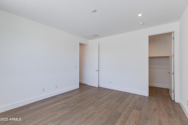 100 W Northern Ave Unit 12, Phoenix, AZ 85021 - unfurnished bedroom featuring recessed lighting, baseboards, wood finished floors, a spacious closet, and a closet