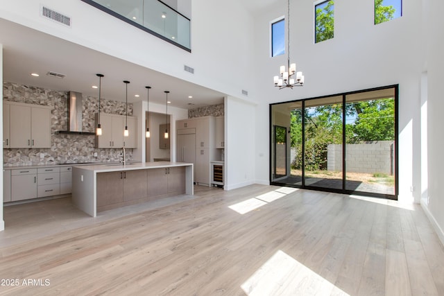 100 W Northern Ave Unit 12, Phoenix, AZ 85021 - kitchen featuring visible vents, a towering ceiling, light countertops, wall chimney exhaust hood, and tasteful backsplash