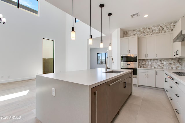 100 W Northern Ave Unit 12, Phoenix, AZ 85021 - kitchen with a sink, light countertops, decorative backsplash, visible vents, and a center island with sink