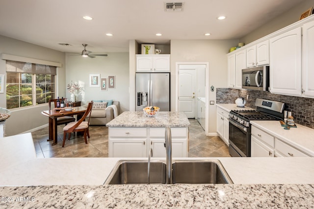 kitchen featuring decorative backsplash, ceiling fan, white cabinetry, sink, and stainless steel appliances